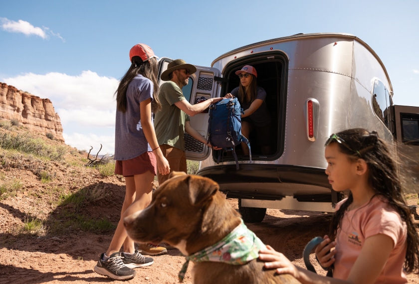 A family unloading their Airstream at a desert site.