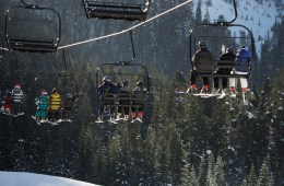 skiers and snowboarders on a chair lift