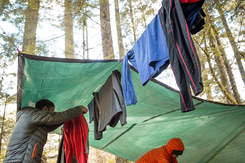 clothes drying out on a line at a campground under a tarp.