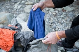 man pulls baselayer out of a bag.