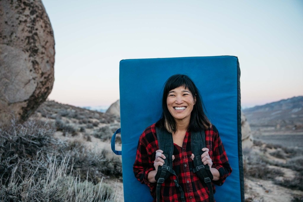 Shelma hiking through the desert with her bouldering pad