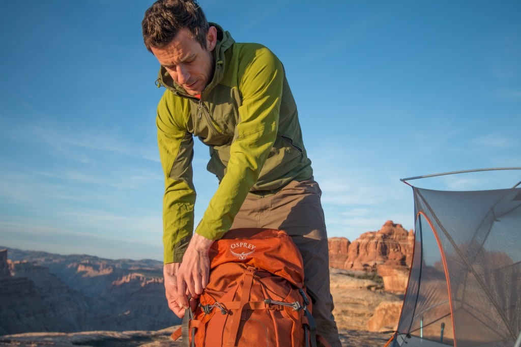 man adjusting backpack wearing Outdoor Research Ferrosi Hoody