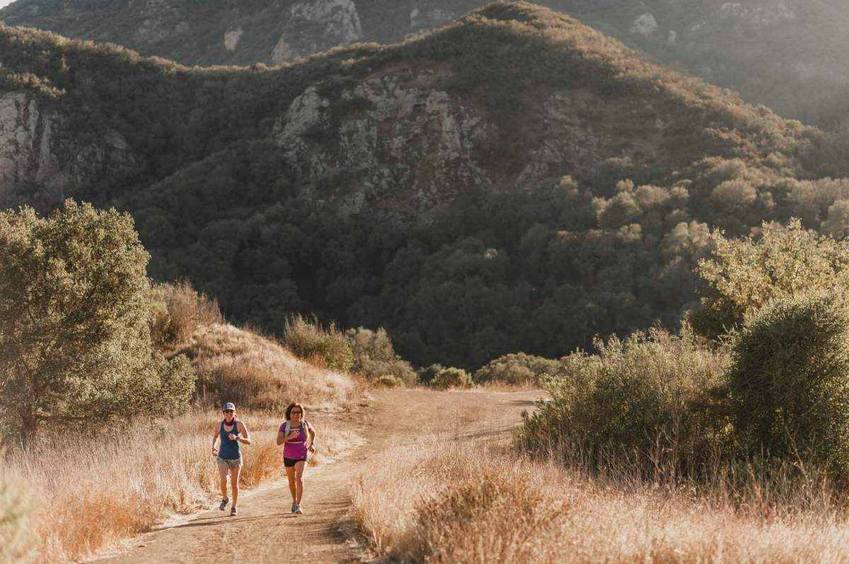 Two runners on a dirt road