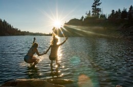 Two people jumping into a lake at REI Outessa Kirkwood