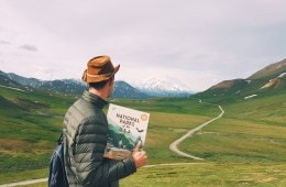 Man looking at Denali with a copy of a book in hand