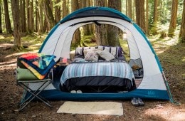 A roomy tent with cots and plush bedding