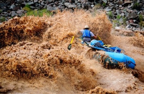 A rafter pushes through Hermit Rapid in Grand Canyon National Park at high water.