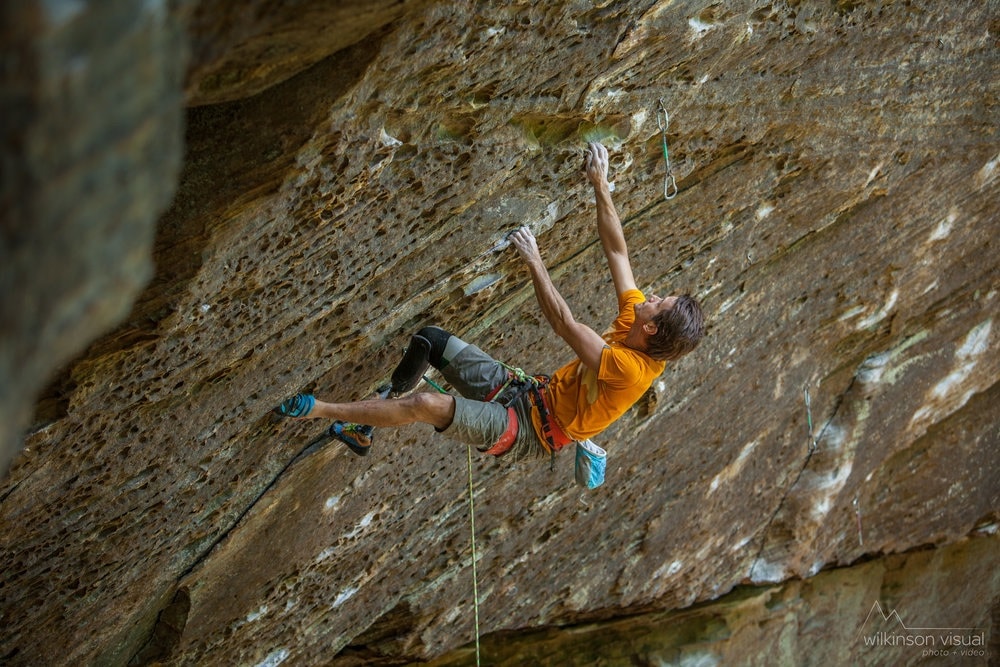 Climber Craig DeMartino reaches for a hold on an overhanging climbing route.