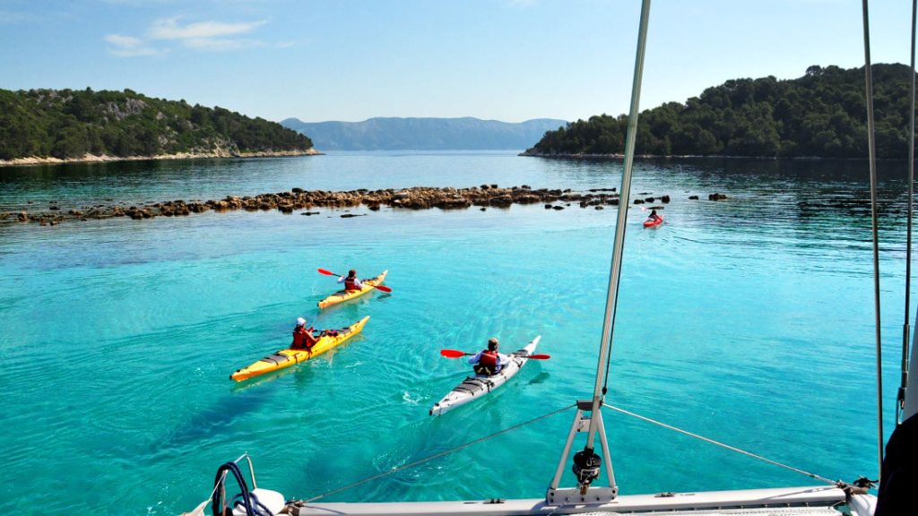 Kayakers paddle the waters of the Dalmatian Coast.