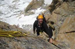 Steve Swenson, in a yellow helmet, looks up while climbing a corner on Latok I in Pakistan's Karakoram range.