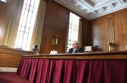 David Bernhardt, wearing a jacket and tie, sitting at a wooden desk