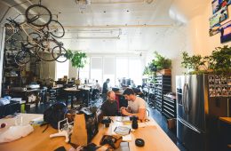 The Peak Design team works together at a desk in their office.