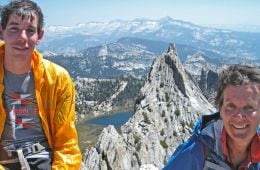 Diedre Wolownick sits on the summit of Matthes Crest with her son, Alex Honnold. In the background the sharp ridgeline of Matthes Crest rises up out of the landscape.