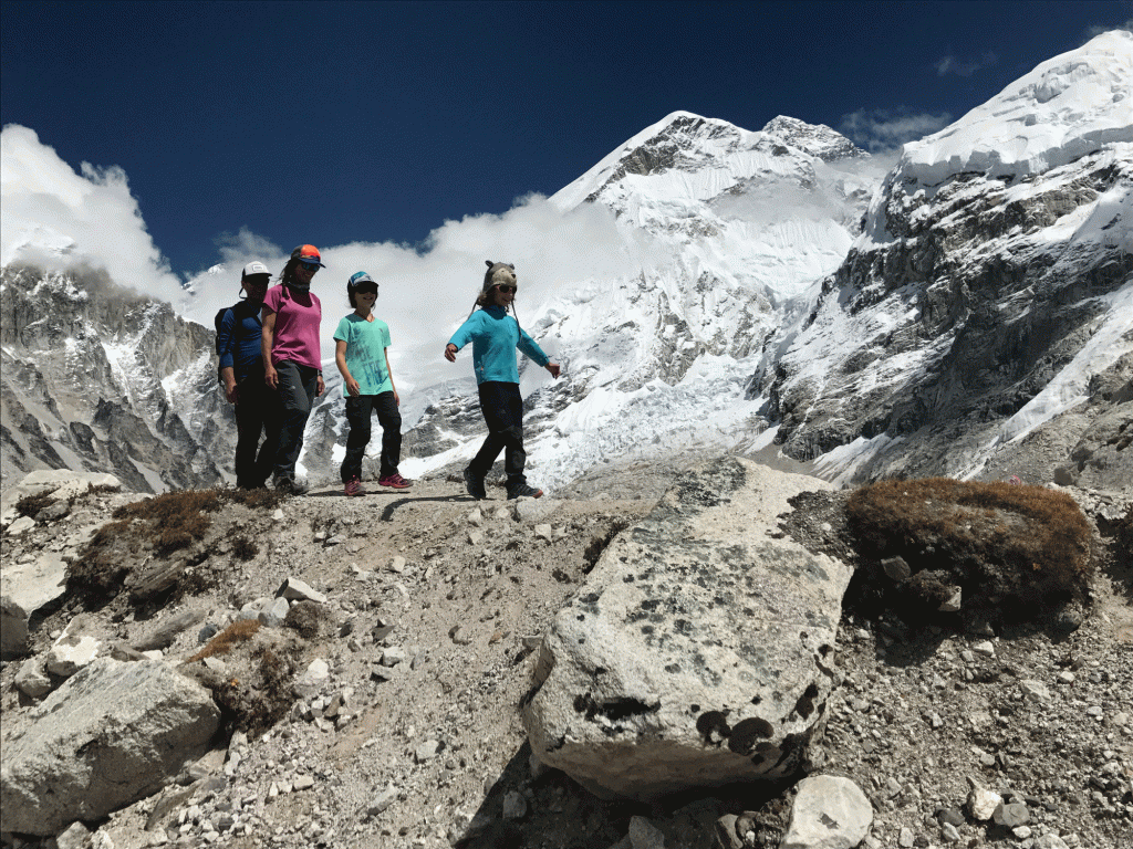 A dad and his kids venture out onto a field composed of rocks and snow