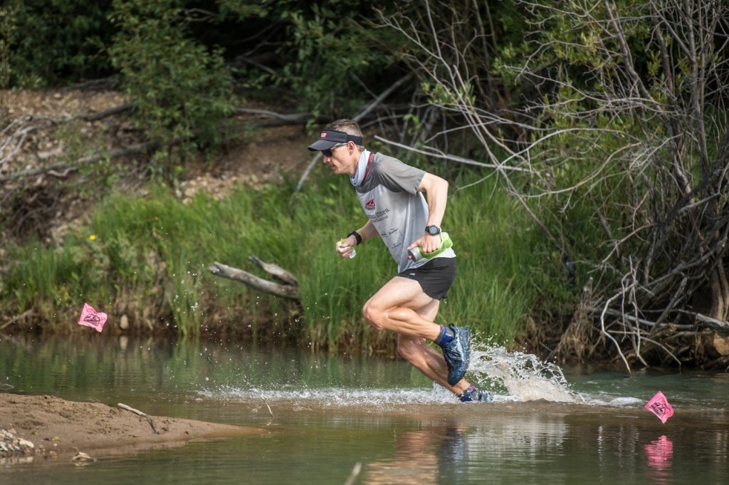 Two-time Leadville champion Ian Sharman runs through a creek.