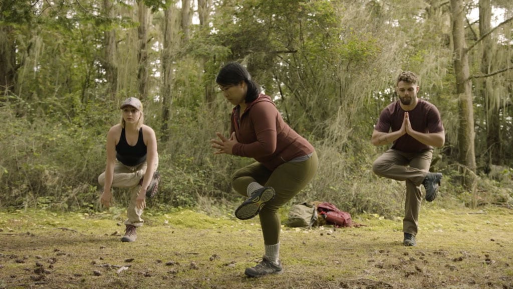 CorePower Yoga instructors hold standing figure 4 pose