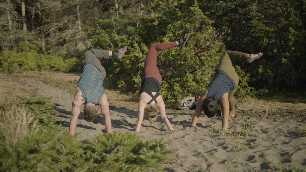 Corepower yoga instructors hold three-legged down dog pose