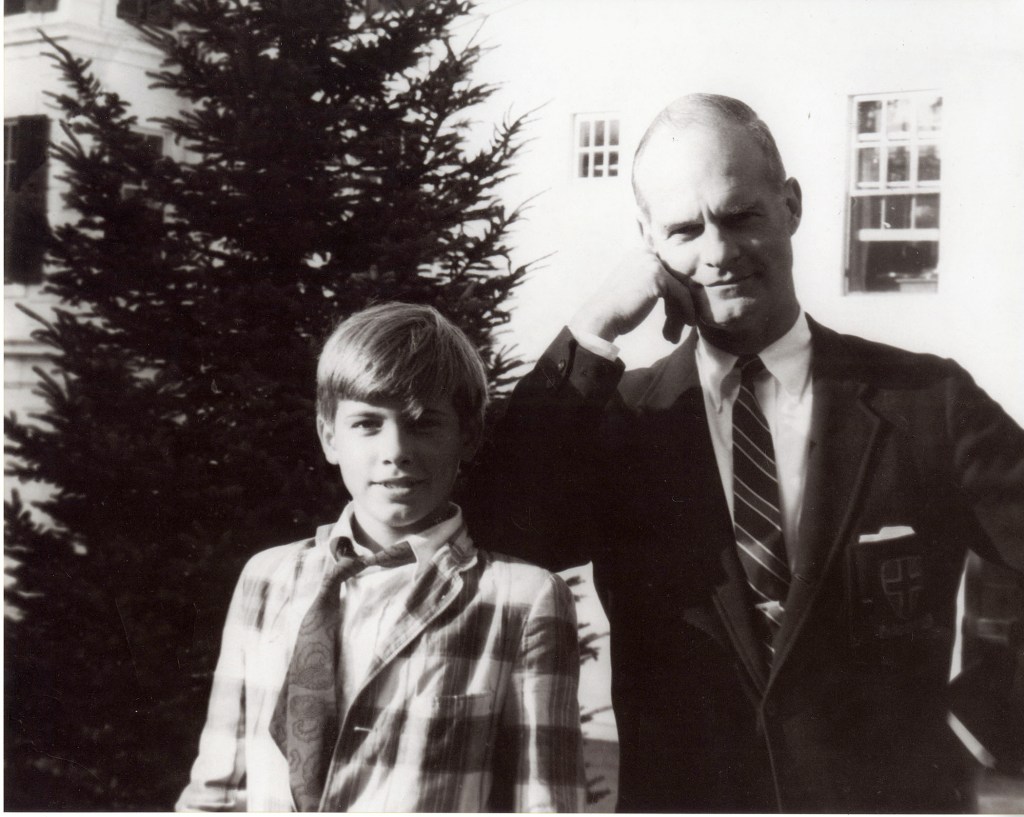 A young boy poses with his father in a formal outfit