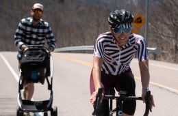 Laura King rides her bike while her husband pushes a stroller with their daughter, Hazel, behind her.