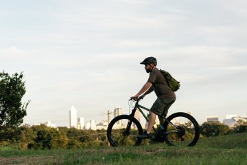 Person riding bike with city in background.