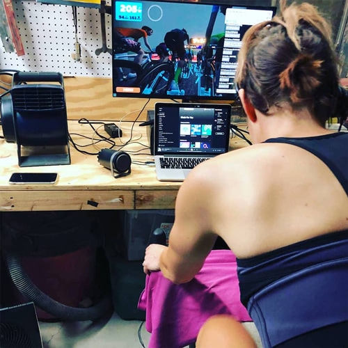 the author pedals on her indoor bike in her basement.