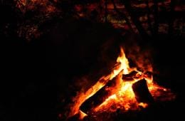 A campfire at night under a dark red sky