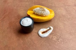 Photo of a sliced mango and bowl of coconut milk.