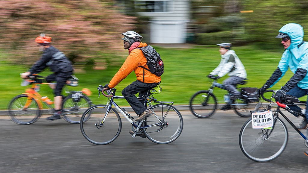 Four cyclists riding bikes as part of Peace Peloton event.