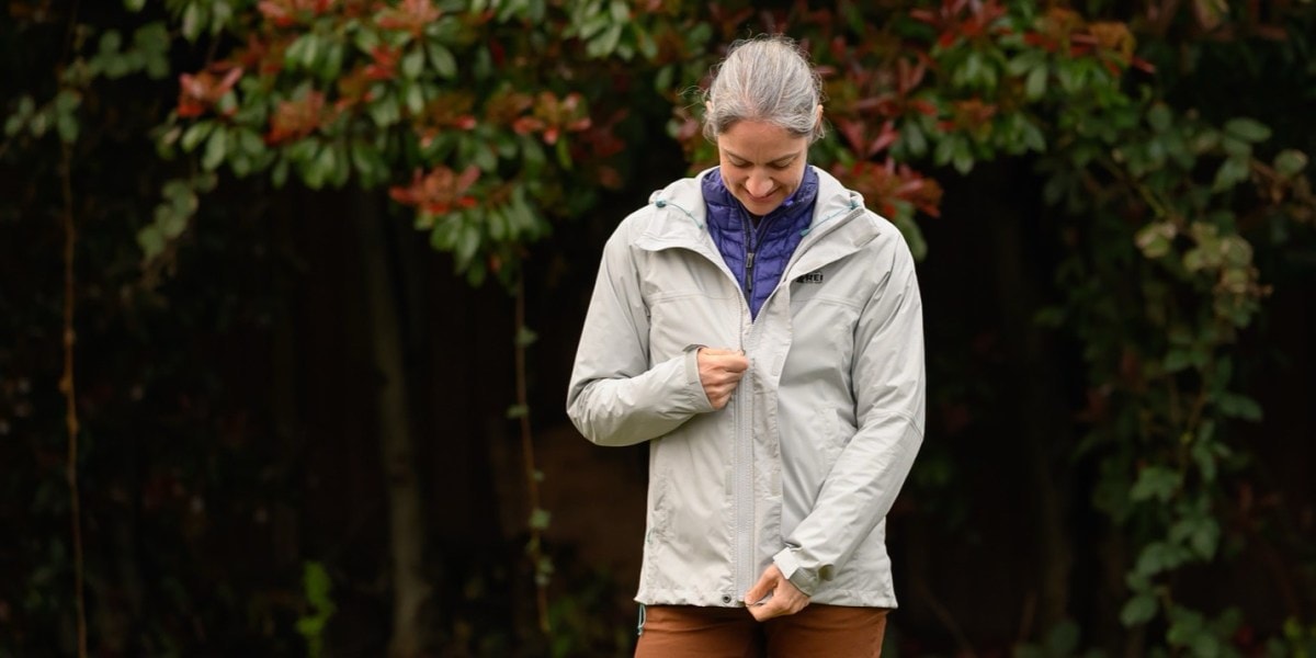 The author wears a base layer and purple insulated puffy jacket underneath the Rainier rain jacket to add warmth.