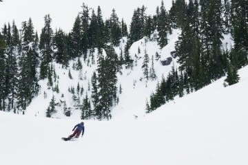 A solo snowboarder in a snowy mountain landscape.