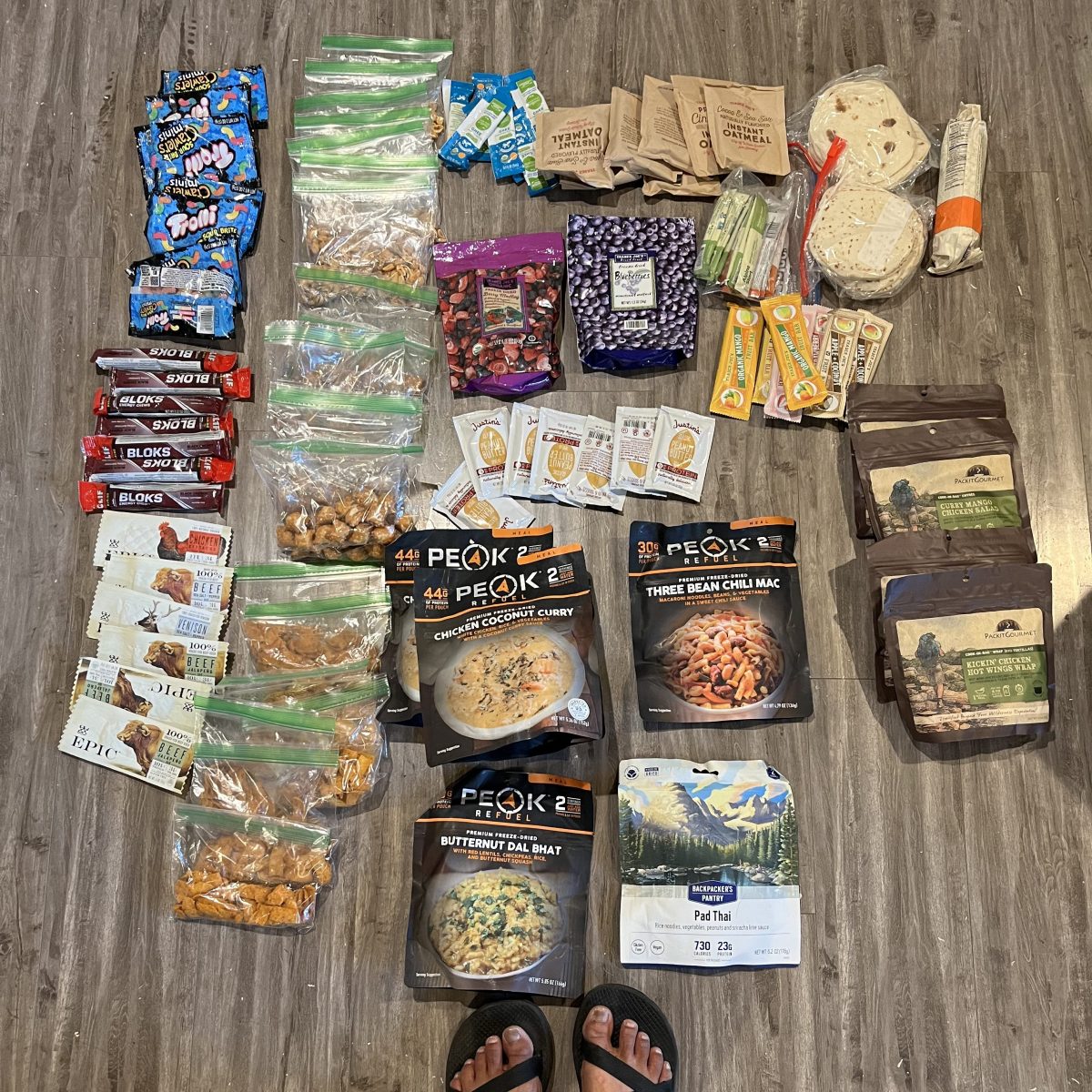 A photo of a portion of the writer's food for her hike. It includes dehydrated fruit, dehydrated dinners, gels, jerky and more.