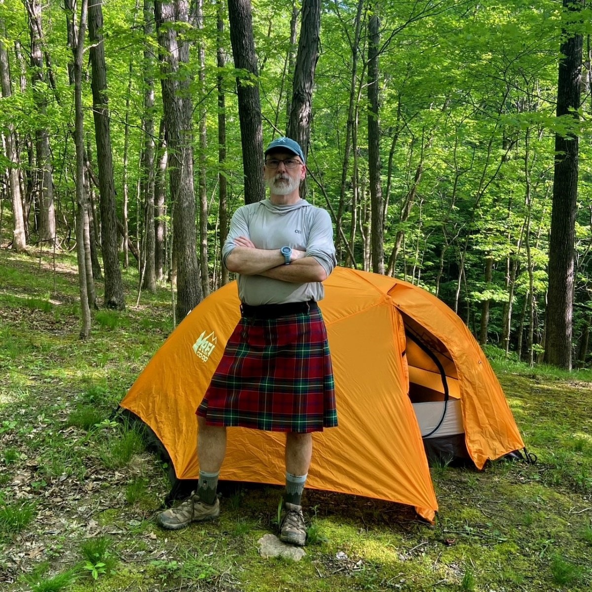 Photo of a man wearing a kilt standing in front of his Half Dome tent