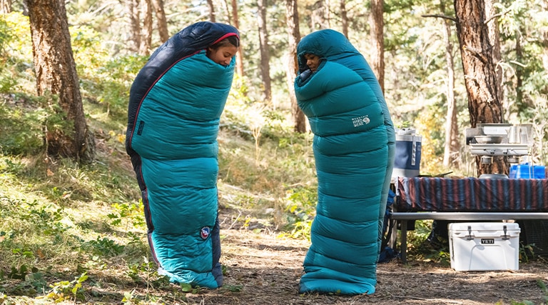 Two campers standing in their sleeping bags