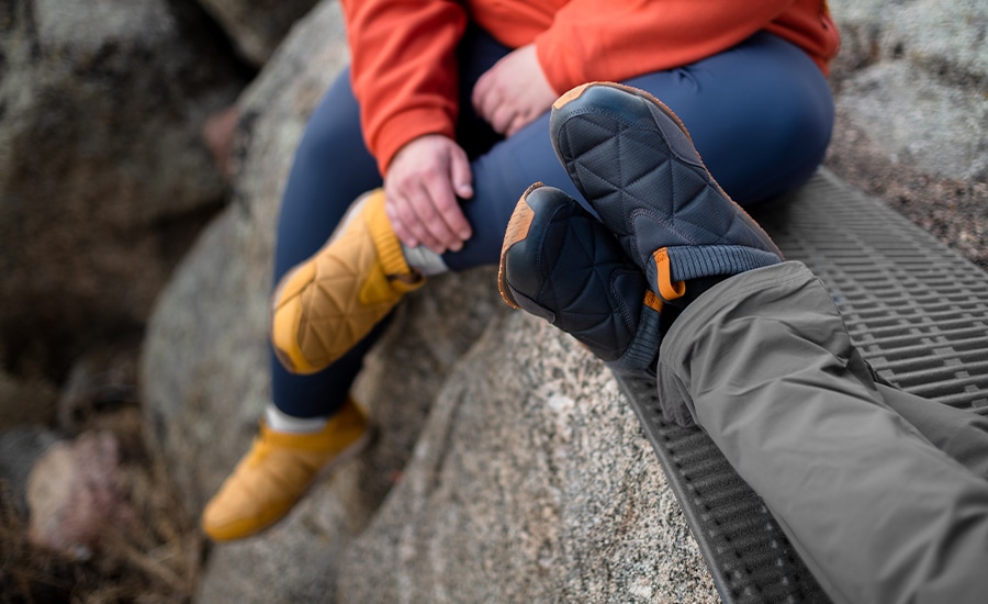 A camper wears the Teva ReEmber slip-ons at a campsite