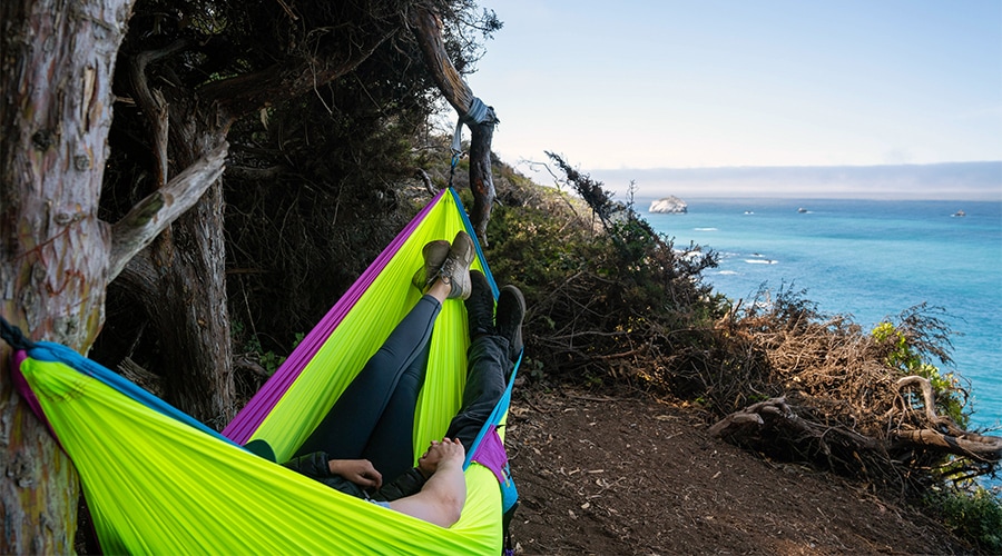 Two people relax in an ENO Doublenest hammock