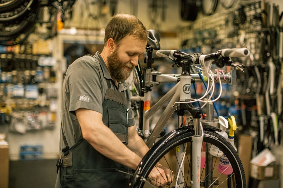 R E I bike tech working in the shop.