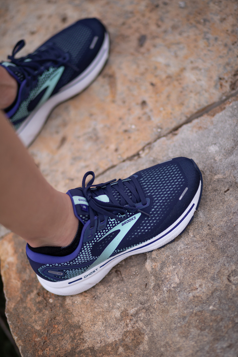 A bird's eye view of a person's foot wearing Ghost 16 shoes on a rock.