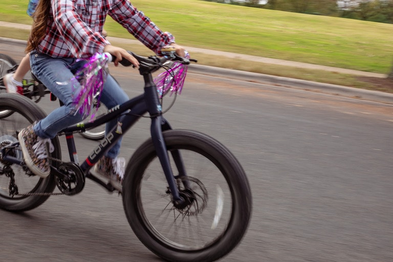 a child rides a blue bike with gears