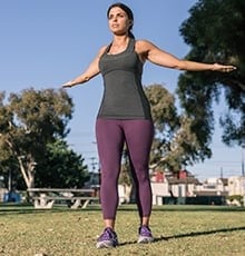 Person doing standing chest stretch with arms outstretched