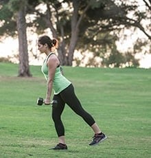 Finishing a single-leg Romanian dead lift in a park