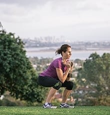 Woman squatting with dumbbell