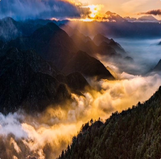 partly cloud skies with sub beams stretching out over a mountainous, wooded valley