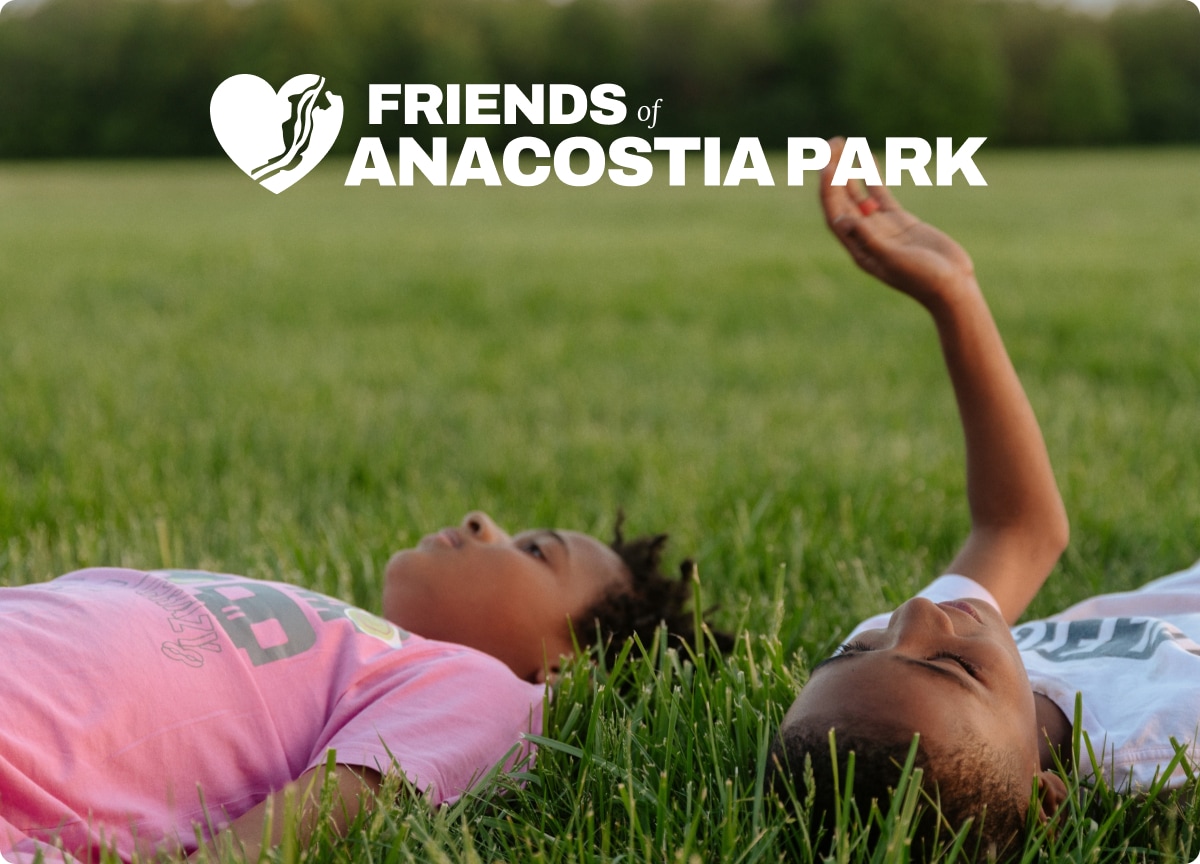 Children laying in the grass. Text reads, Friends of Anacostia Park.