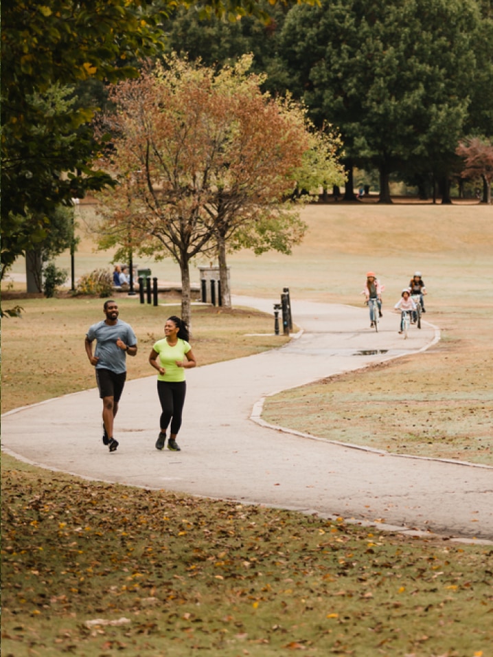 Runners and cyclist of all ages on an outdoor path.