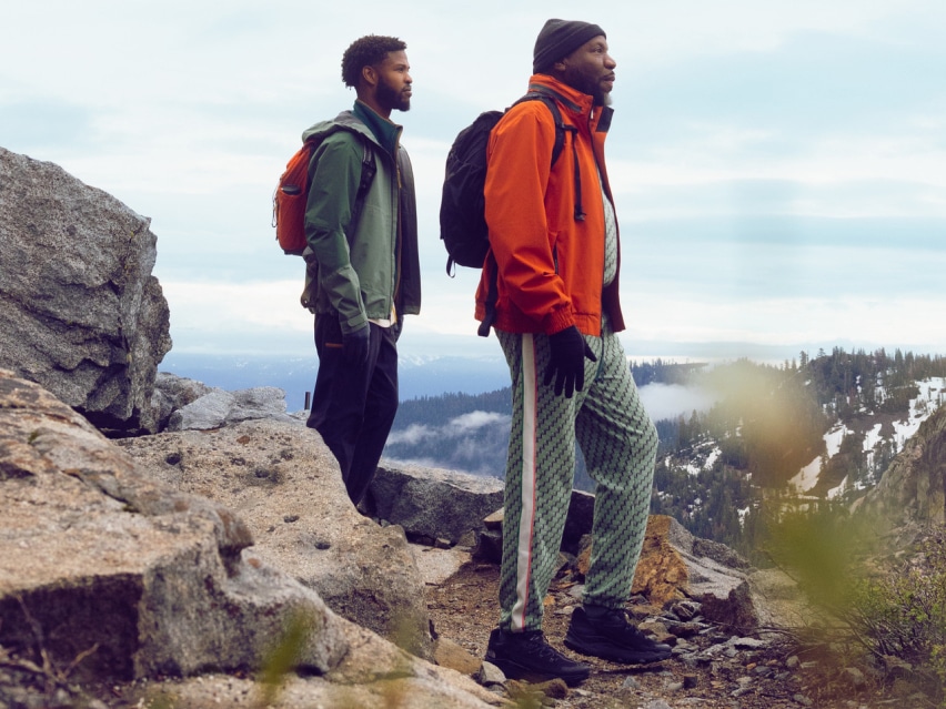 Two hikers look out over a summit.