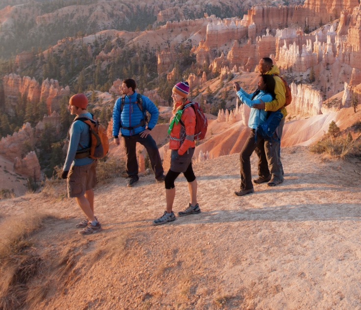 Hikers watch the sunrise over Bryce Canyon.