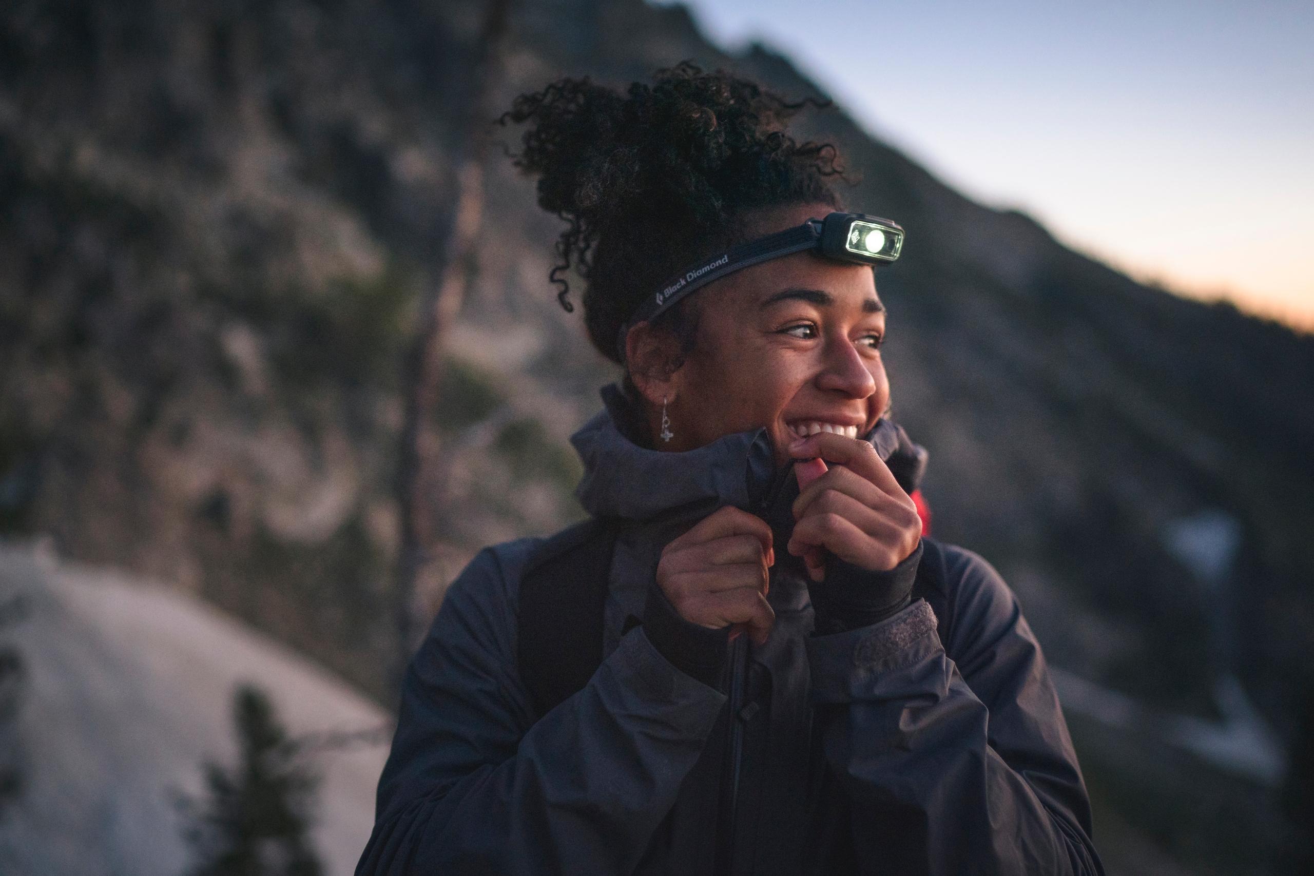 A person in low light hikes wearing a headlamp