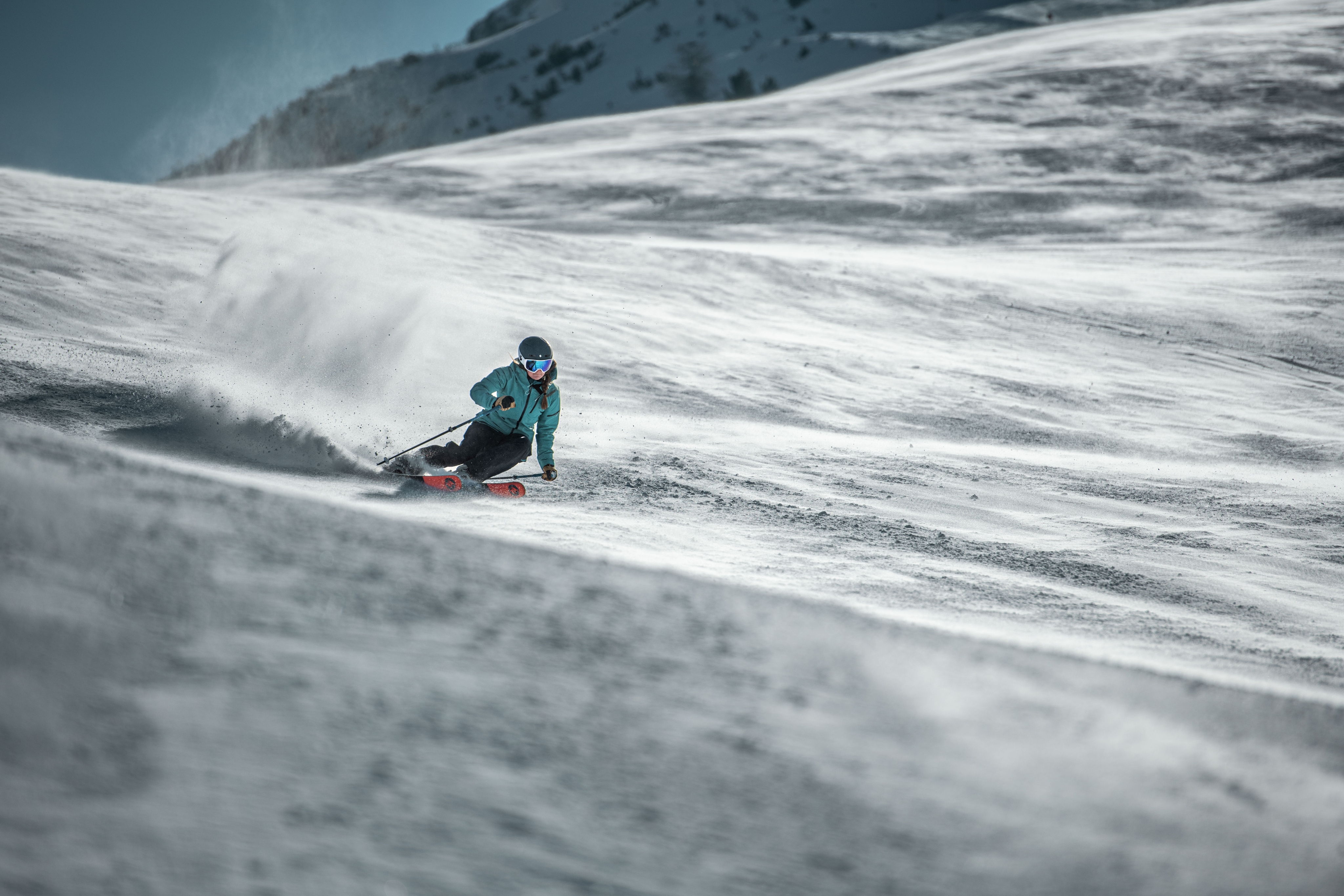 A skier carves through the snow with their Black Pearl skis