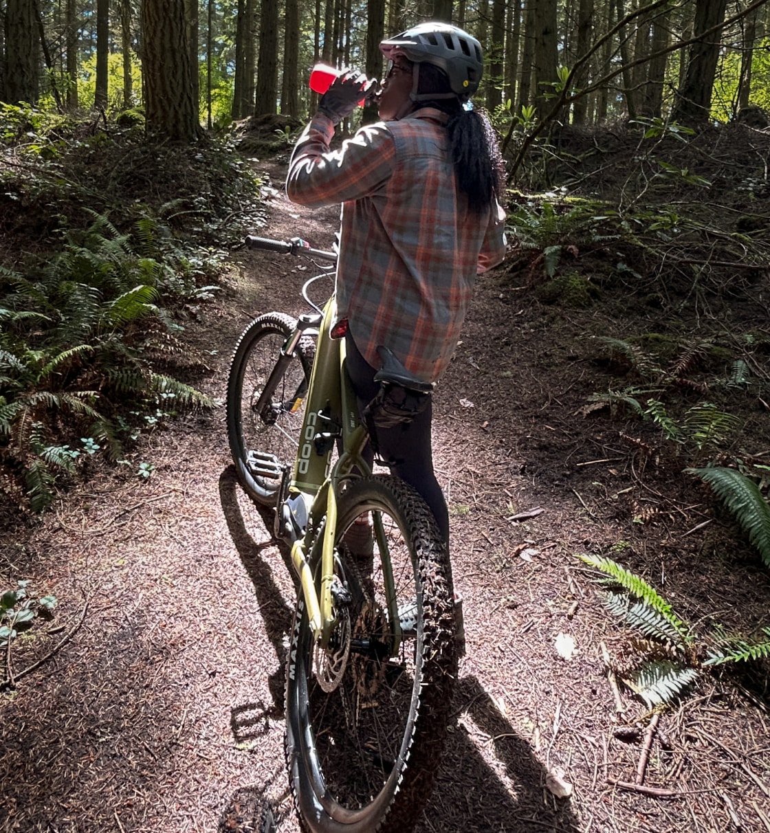 A mountain biker takes a water break while riding the D R T e 1.1 bike.