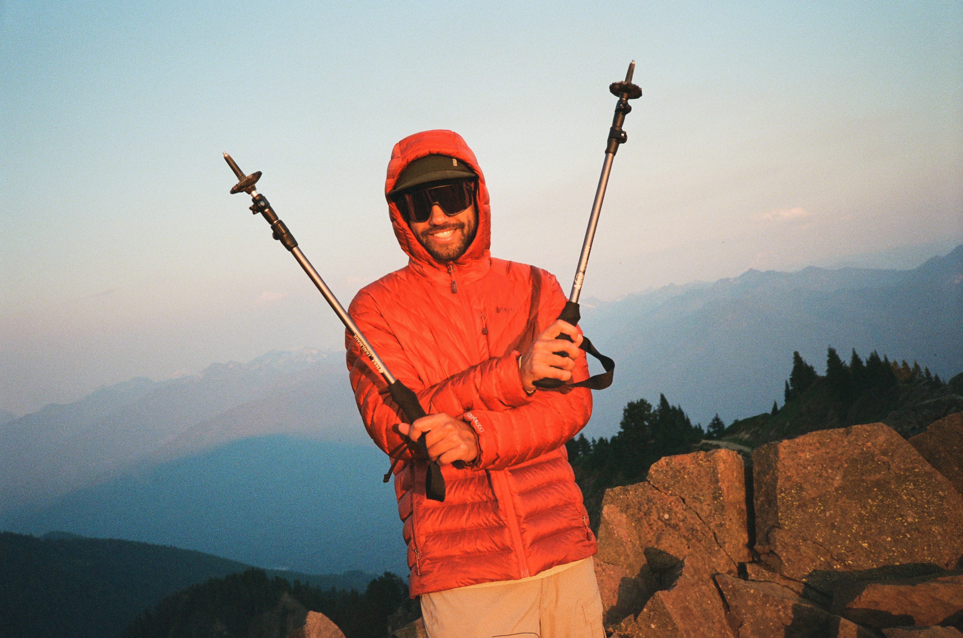 A hiker in R E I Co-op brand gear enjoys a summit sunrise.